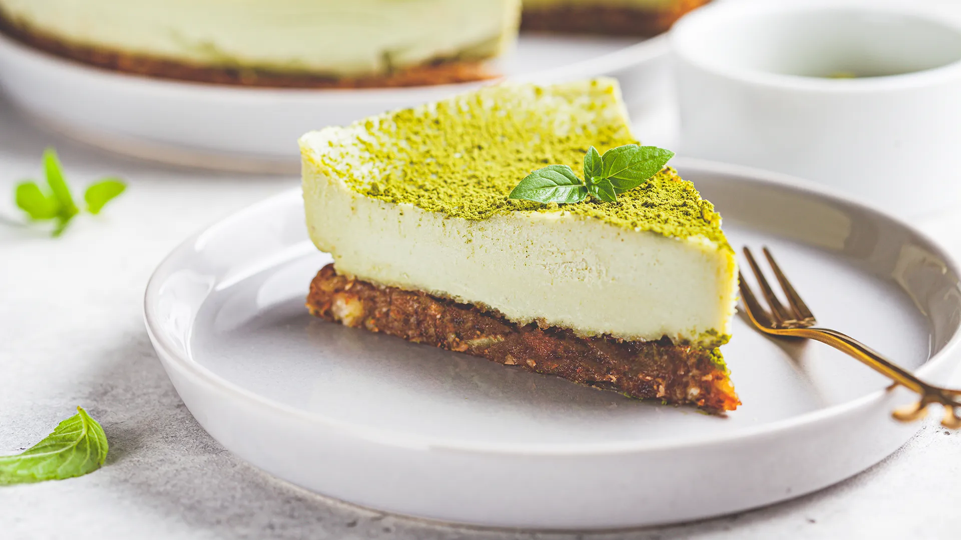 Ein Stück Raw Cake mit grünem Topping auf einem Teller.