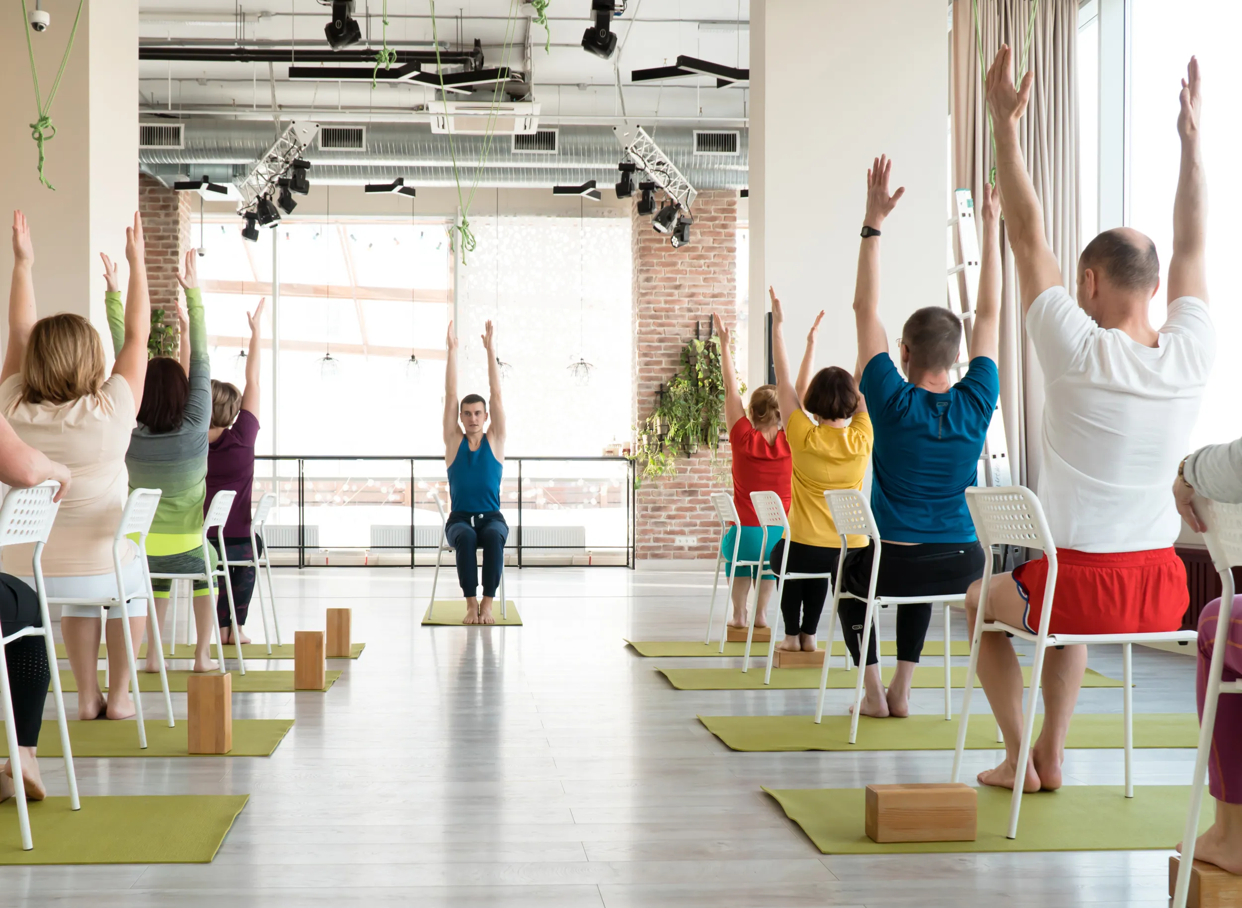 Männer und Frauen machen Yoga auf dem Stuhl