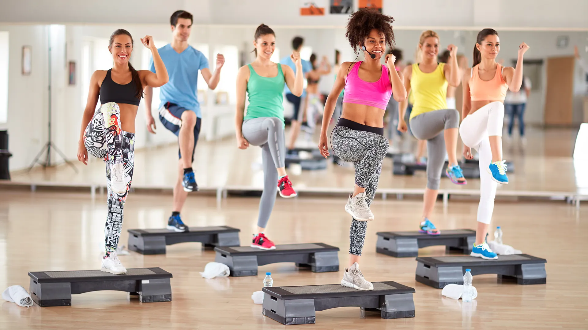 Eine Gruppe von Personen bei einer Step-and-Tone-Session in einem Fitnessstudio.