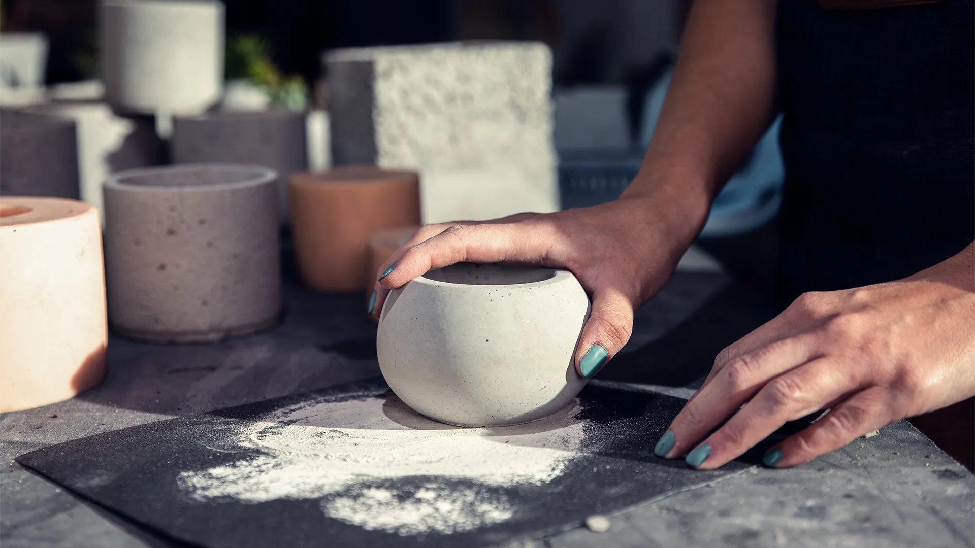 Eine Person formt Kugeln aus Beton.