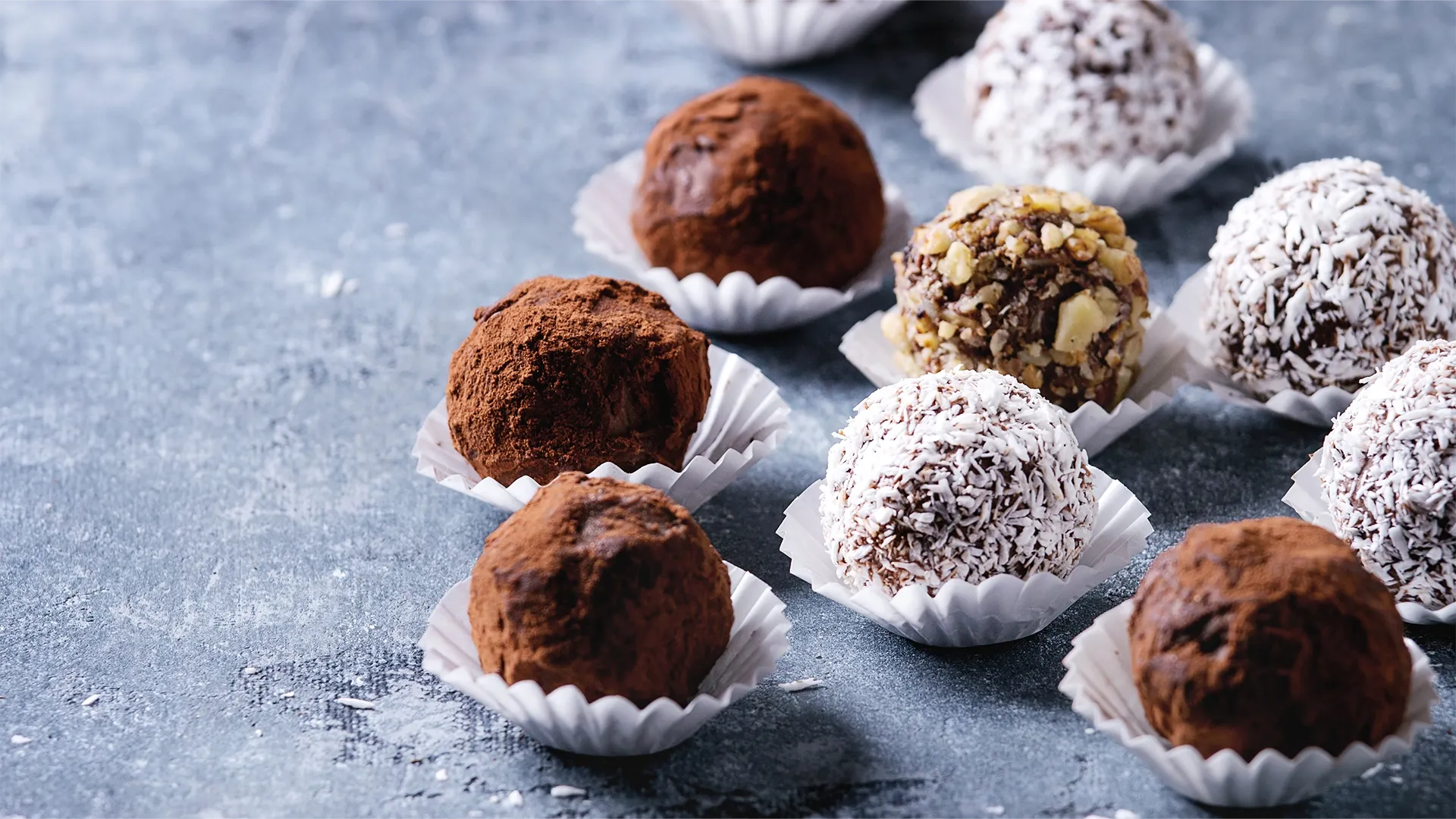 Mehrere Pralines liegen auf dem Tisch in einer weissen Verpackung.