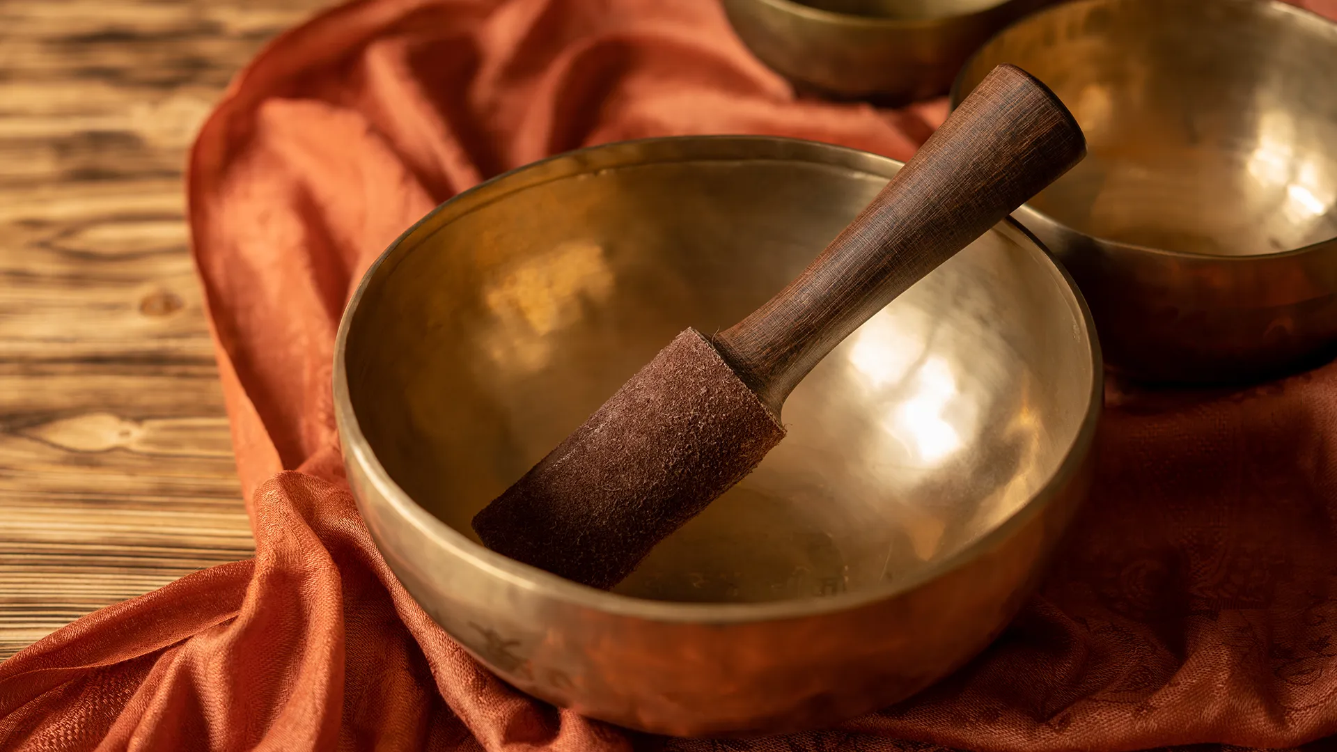 Eine ruhige Szene mit einer Klangschale auf einem roten Tuch.