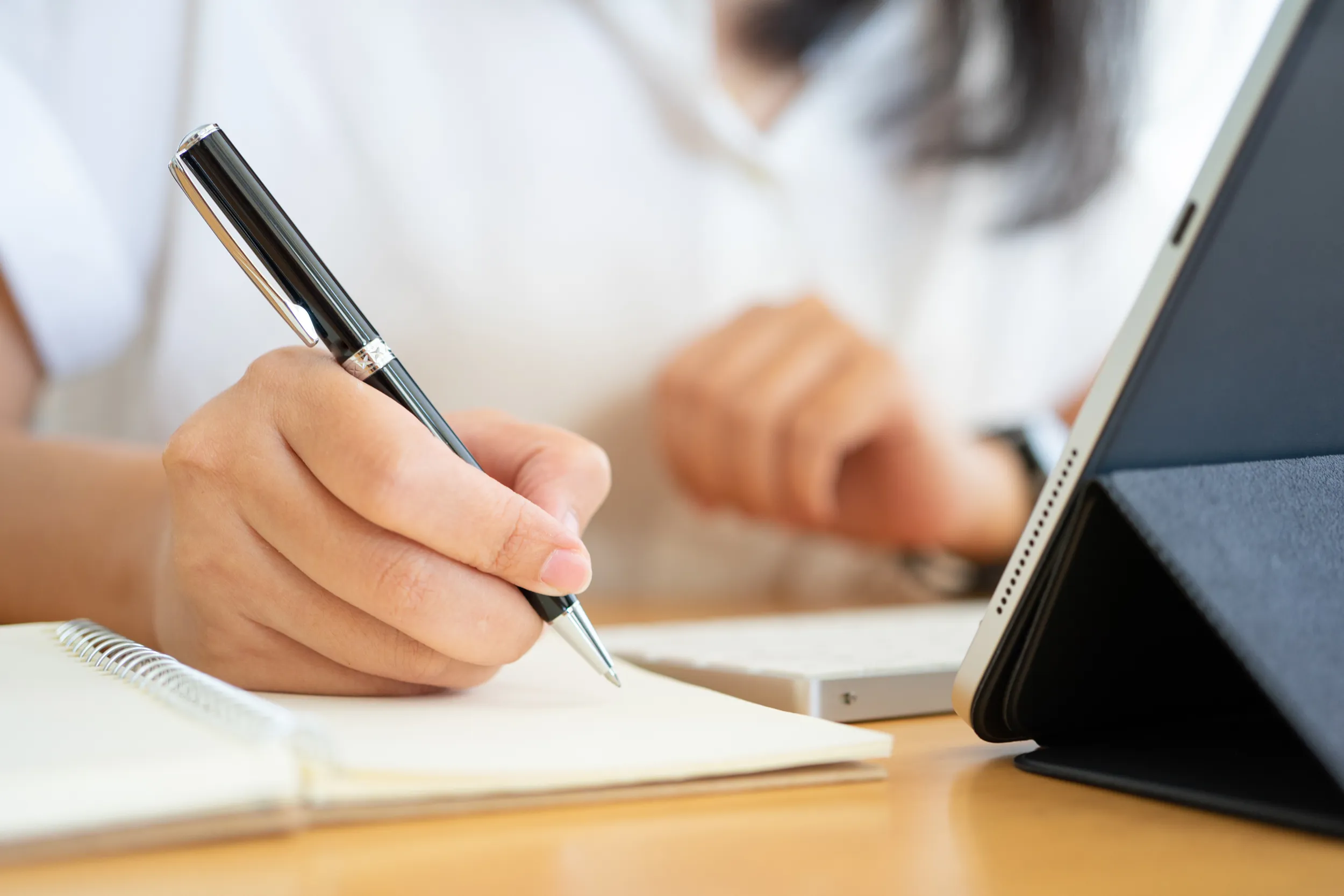 Frau schreibt in ihr Notizbuch