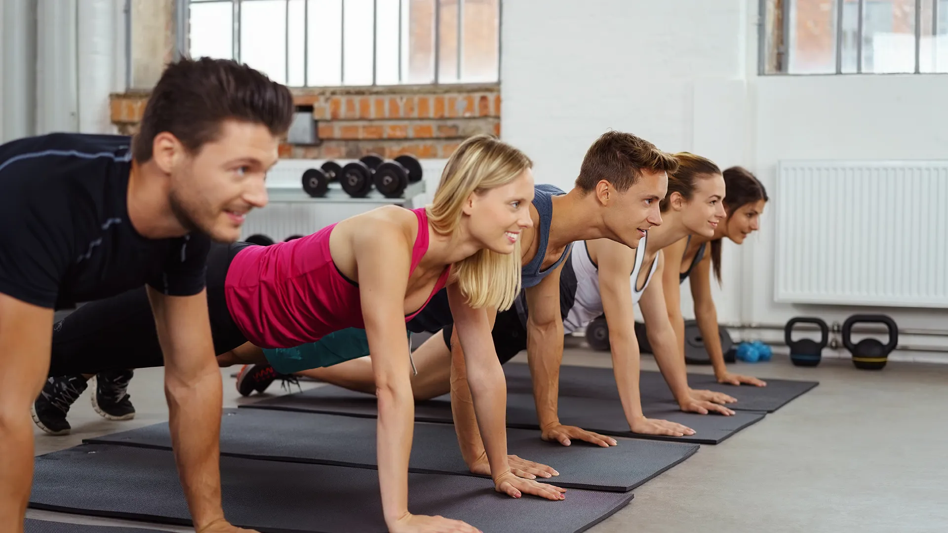 Eine Gruppe macht Gymnastik-Übungen auf Matten.