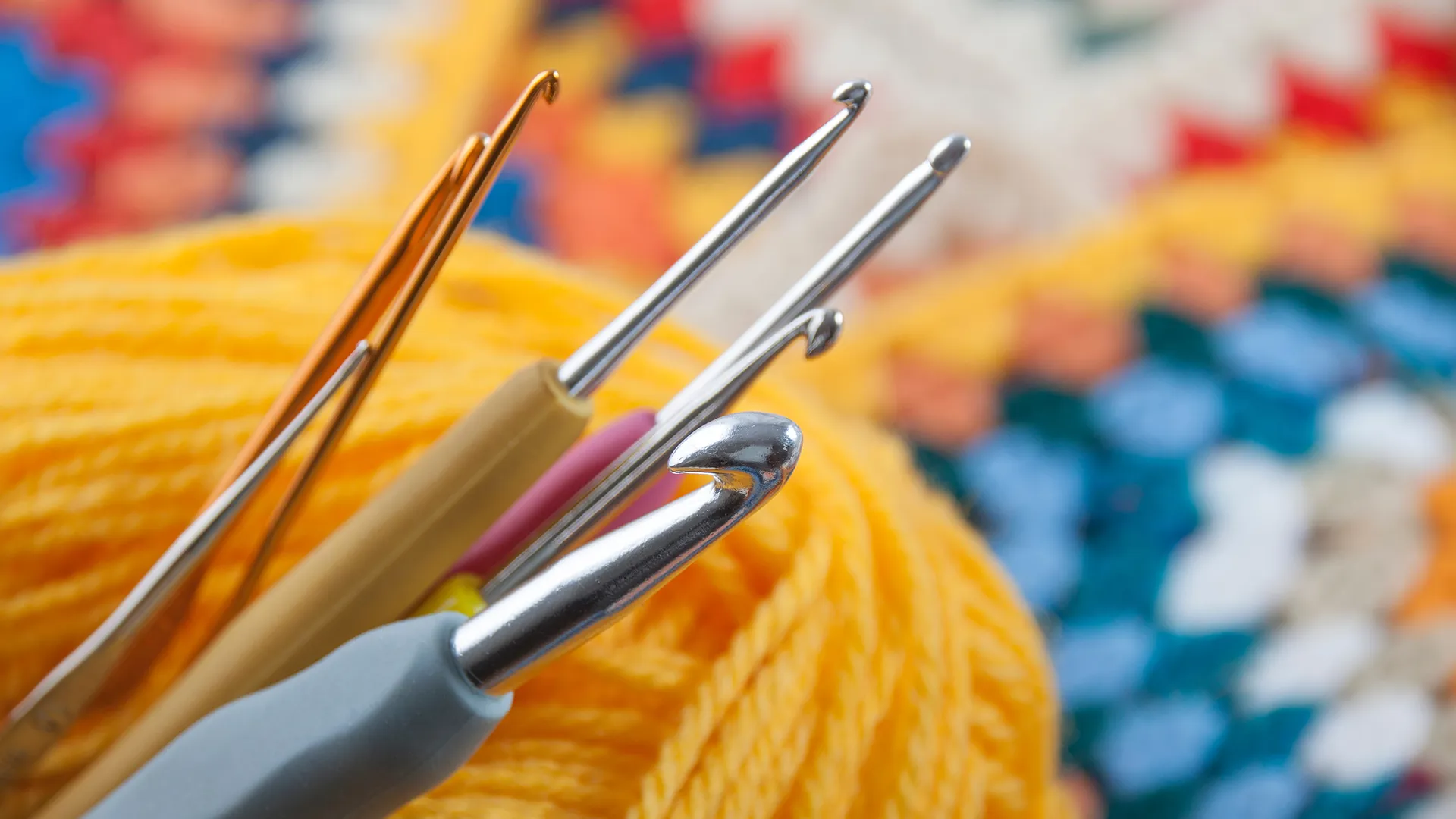 Verschiedene Häkelnadeln und farbiges Garn.