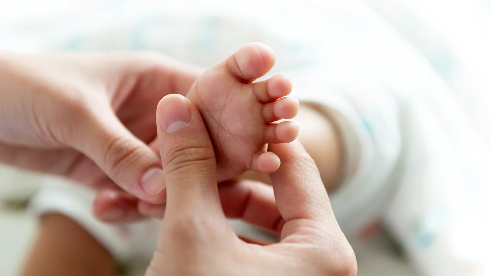 Ein Baby wird an den Füssen massiert.