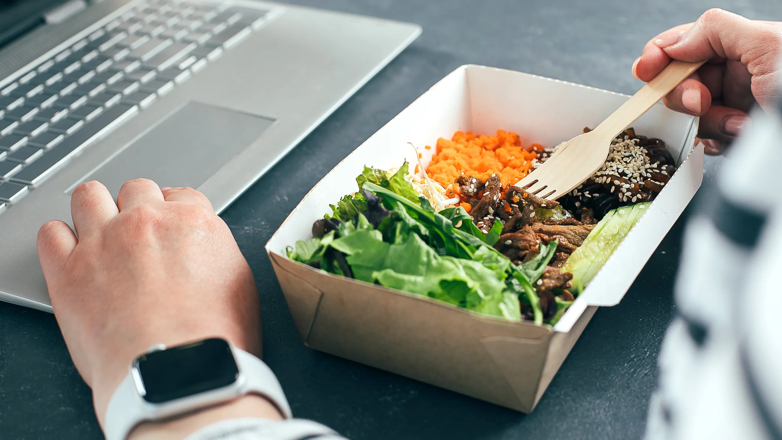 EIne Person isst im Office einen Lunch.