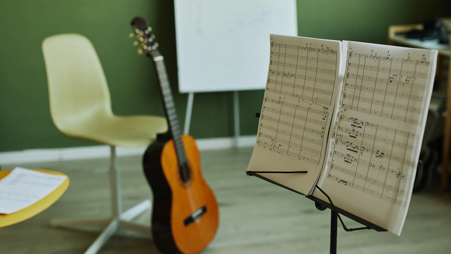 Ein Notenständer und eine Gitarre in einem Musikzimmer.
