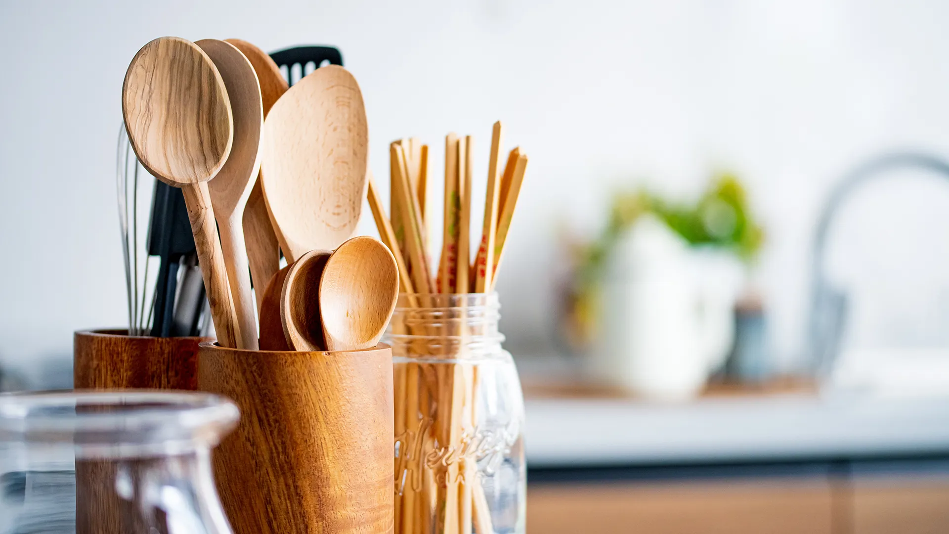 Holz-Küchenutensilien in Behältern, auf einer Arbeitsfläche in einer Küche.