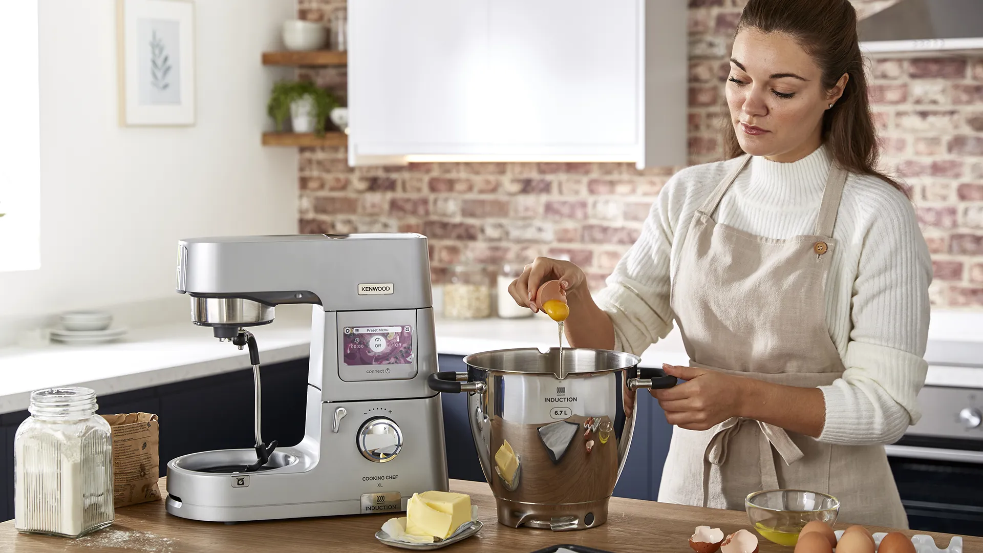 Eine Frau backt ein Rezept mit einer Kenwood-Maschine.