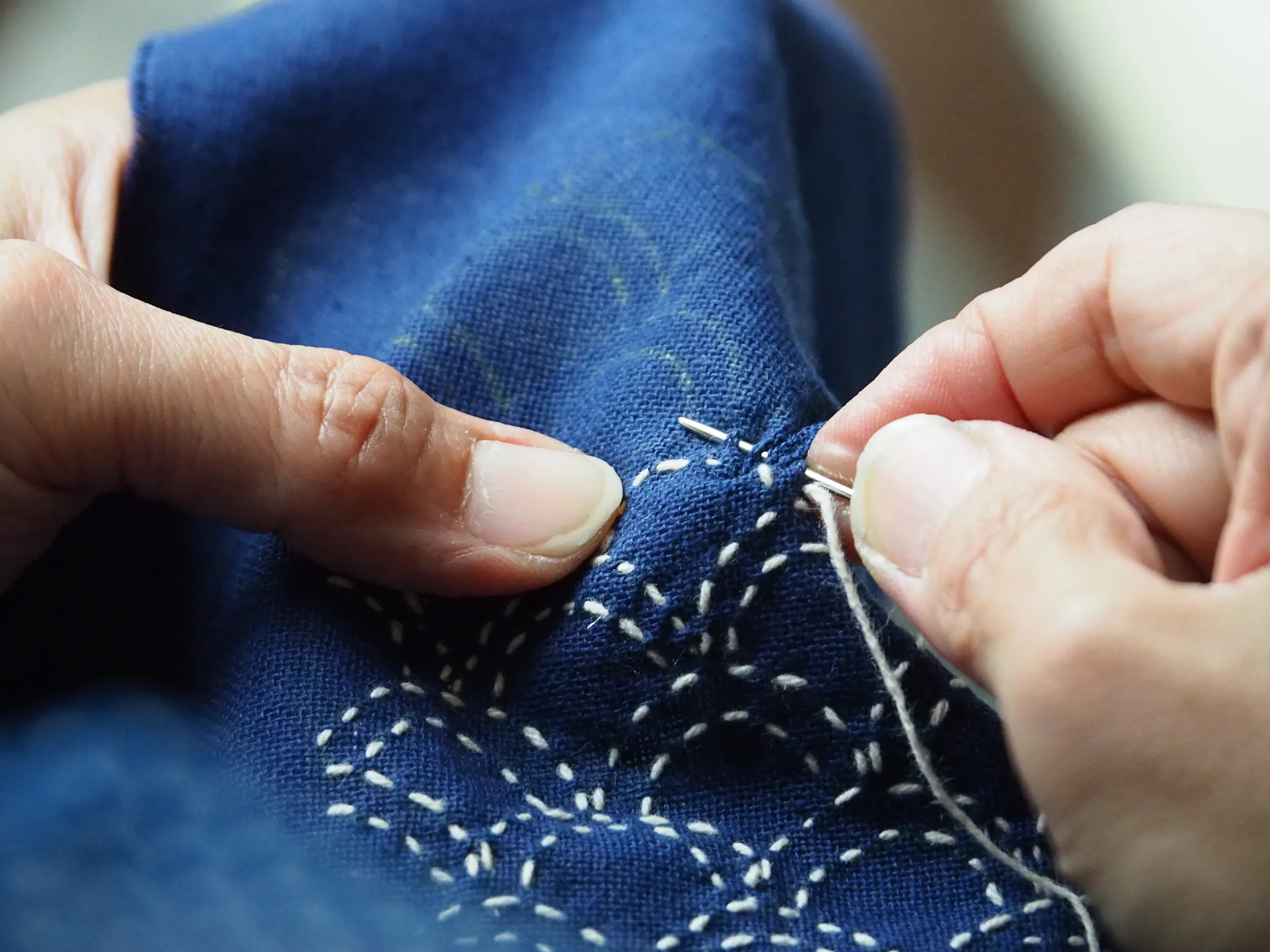 Frau ist am Sashiko sticken