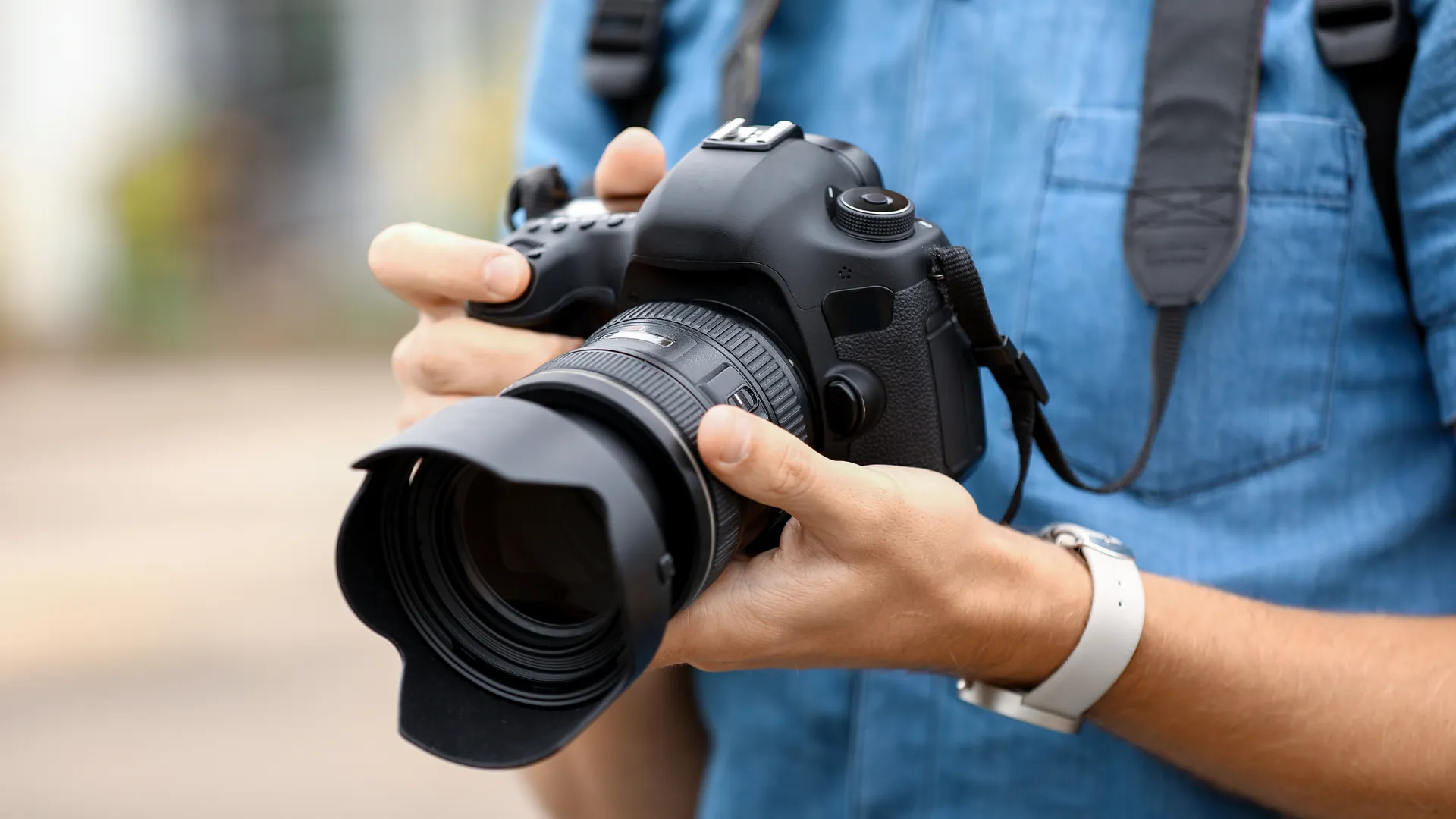 Ein Fotograf hält eine Kamera in der Hand.