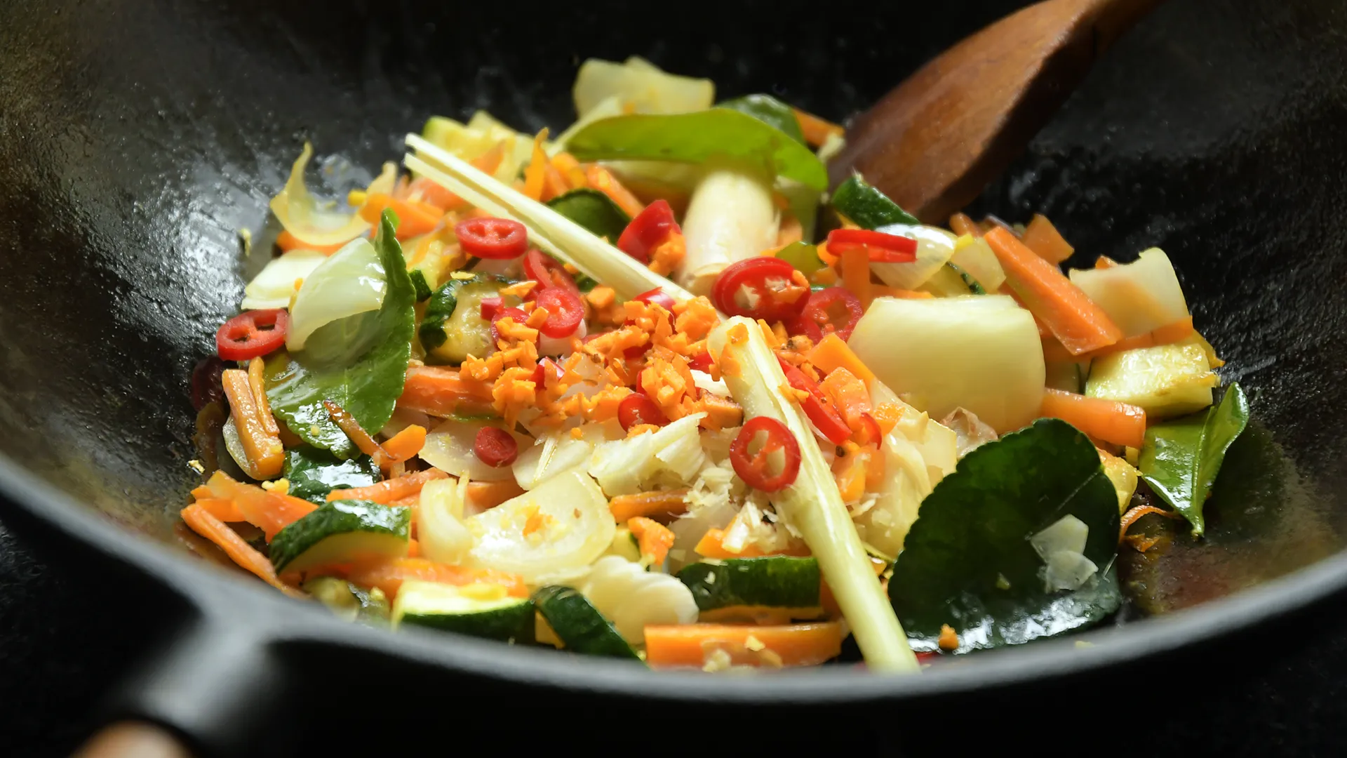 Ein Gericht wird in einer Wok-Pfanne gekocht.