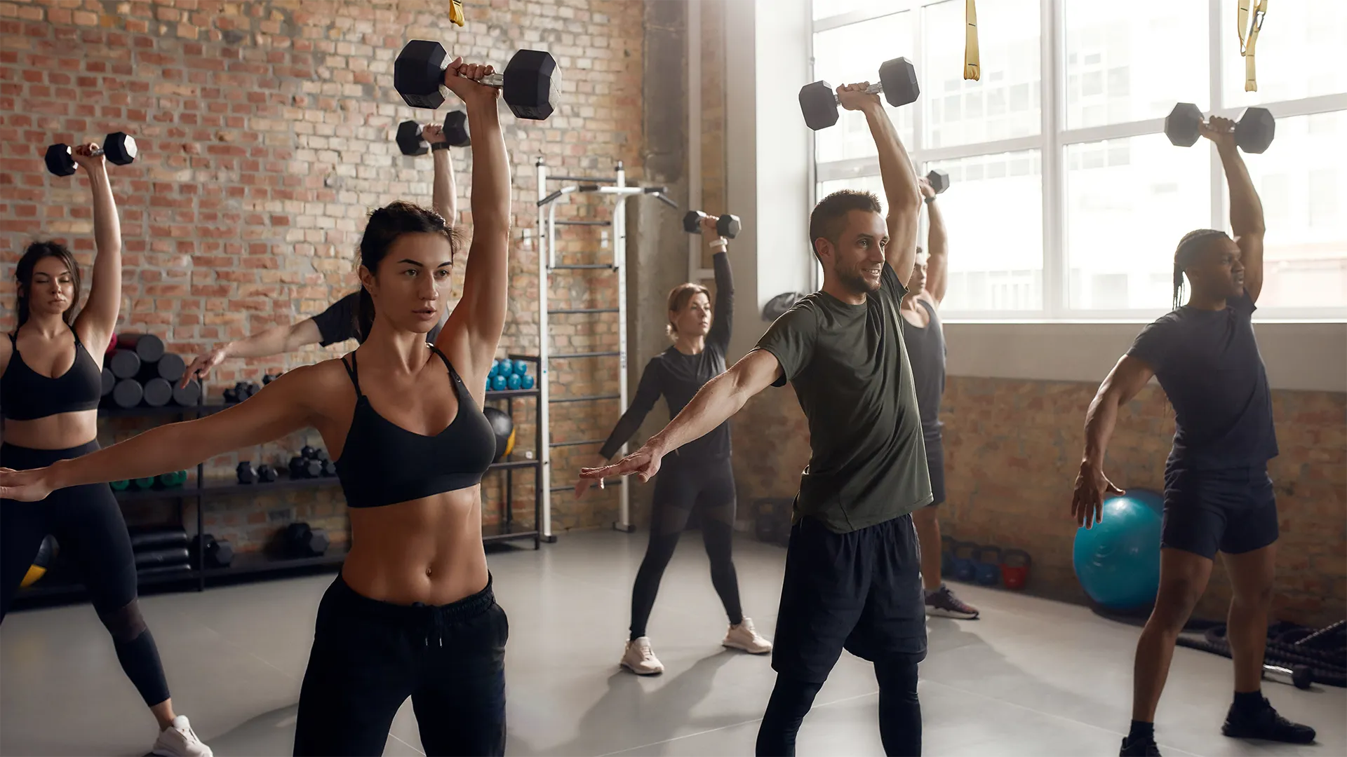 Eine Gruppe trainiert mit Kleinhanteln. Der Fokus liegt auf Bodytoning und Kraftaufbau.