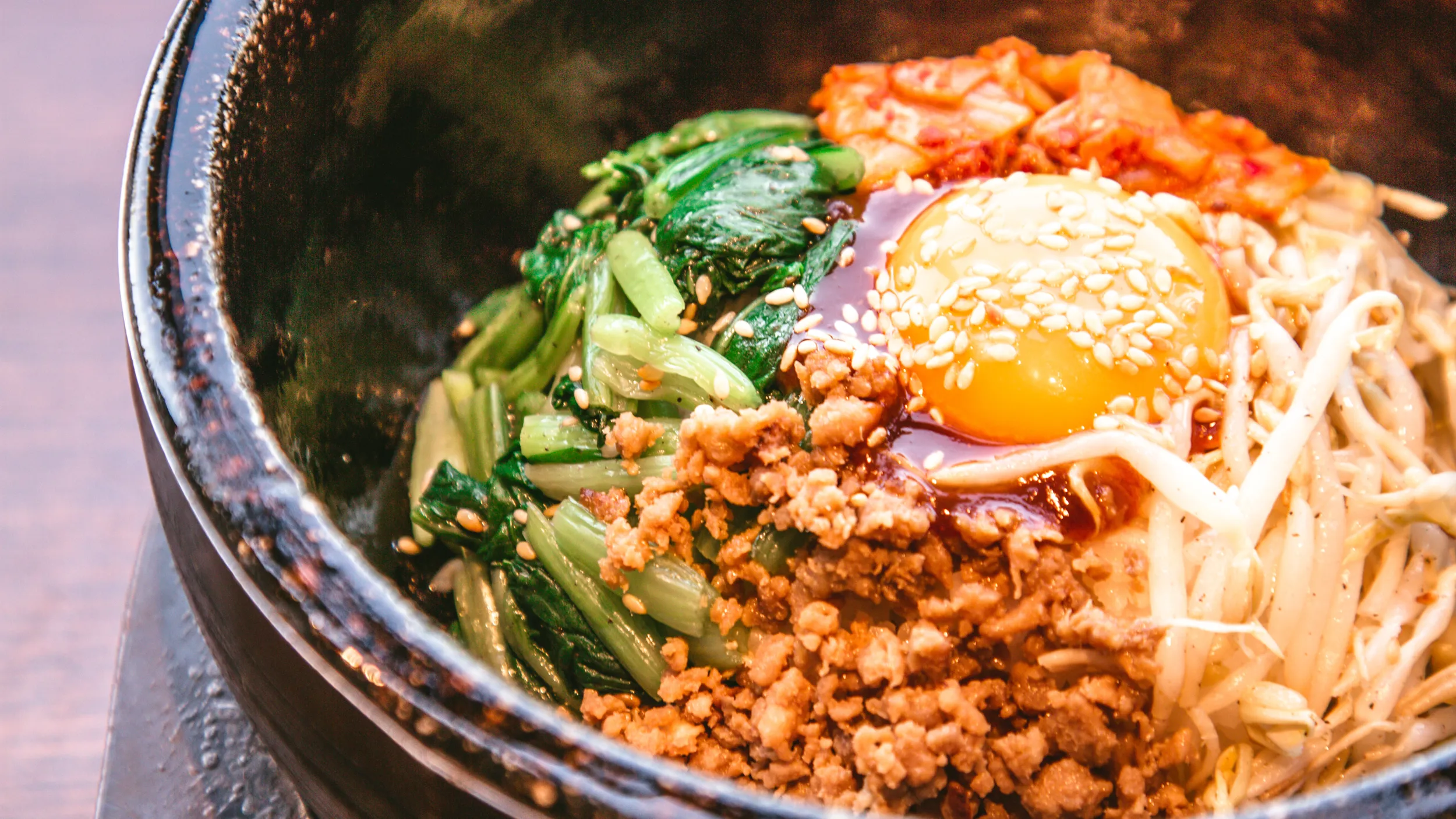 Ein traditionelles koreanisches Bibimbap serviert in einer Steinschale.
