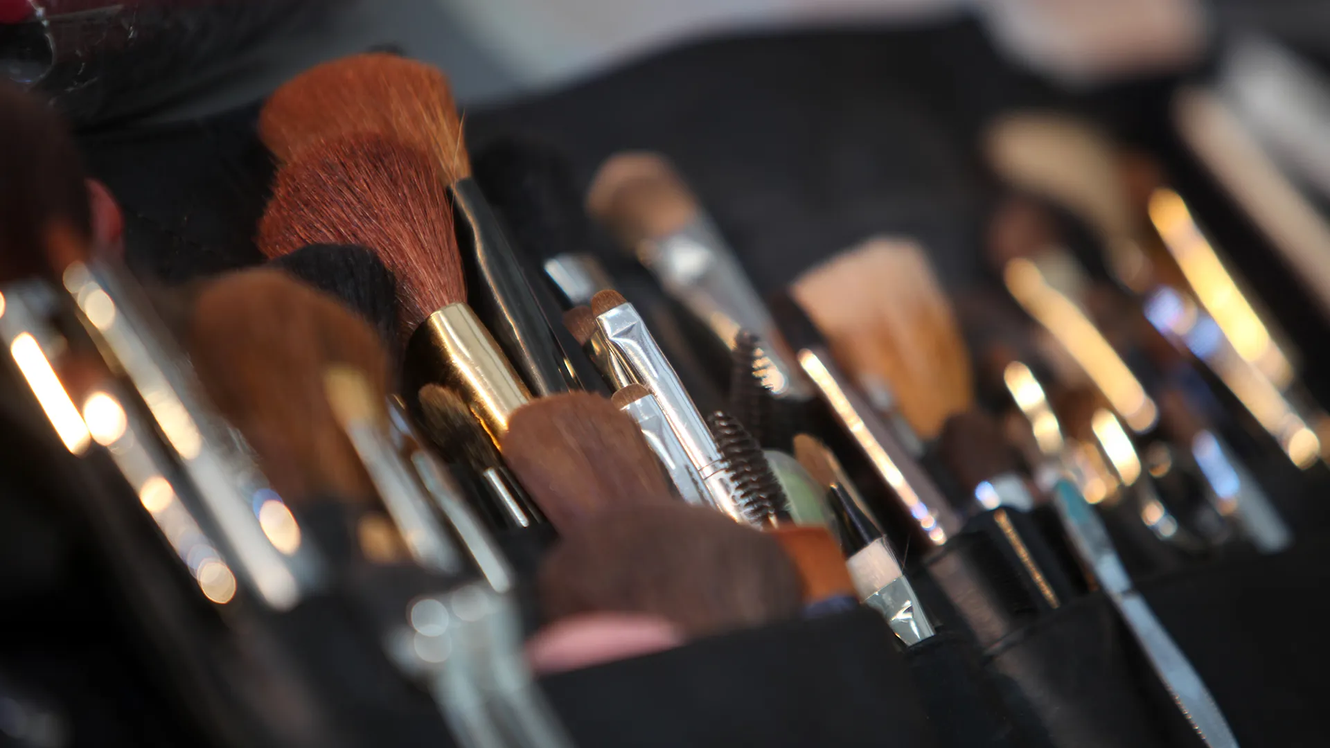 Verschiedene Schminkutensilien liegen in einer Tasche.