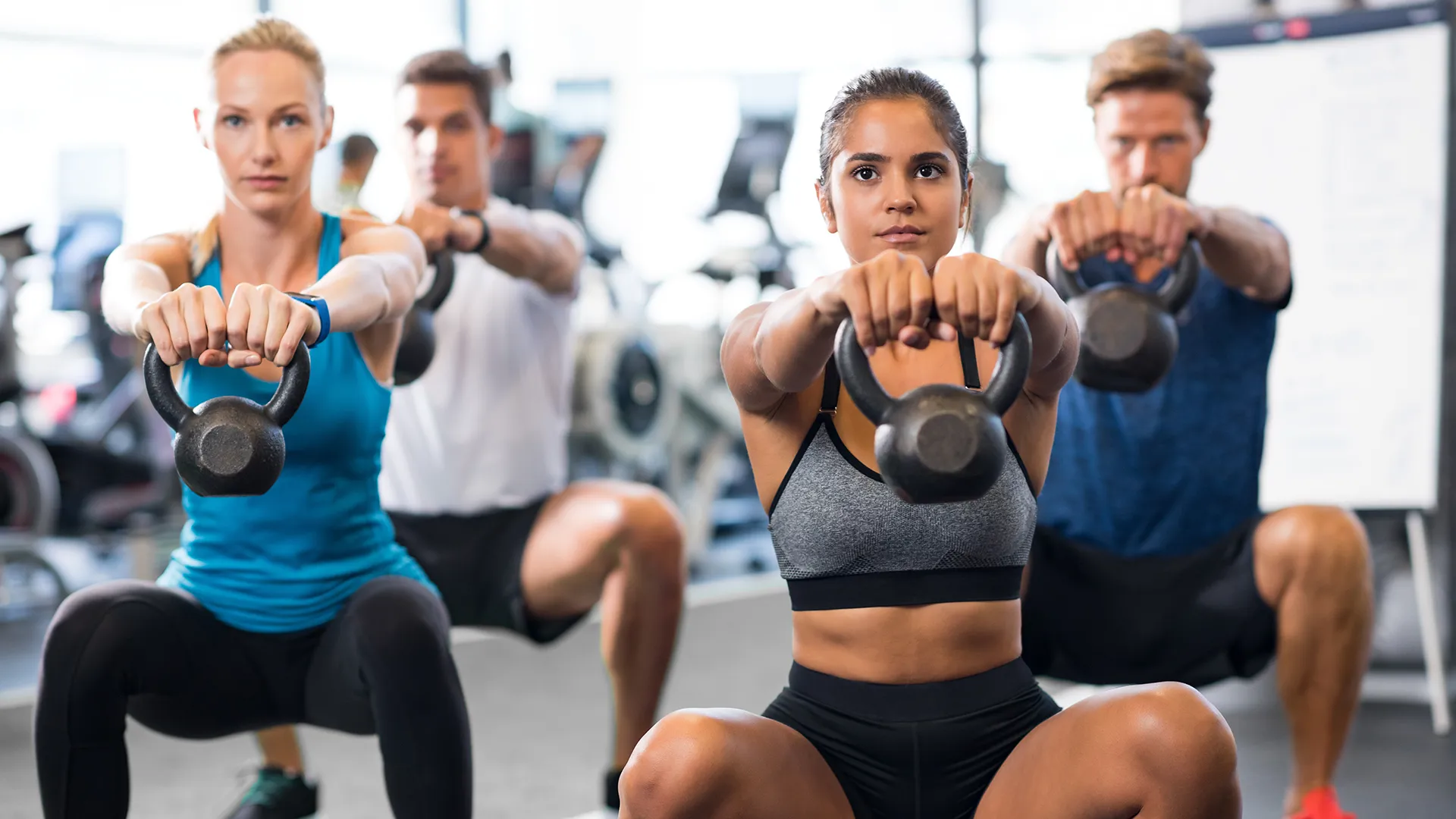 Eine Gruppe trainiert mit Kettlebells. Der Fokus liegt auf Bauch, Beine und Po.